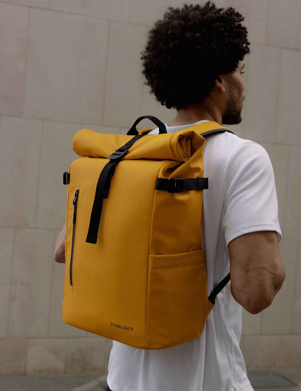 Yellow roll-top backpack with roll-top closure and front vertical zip pocket