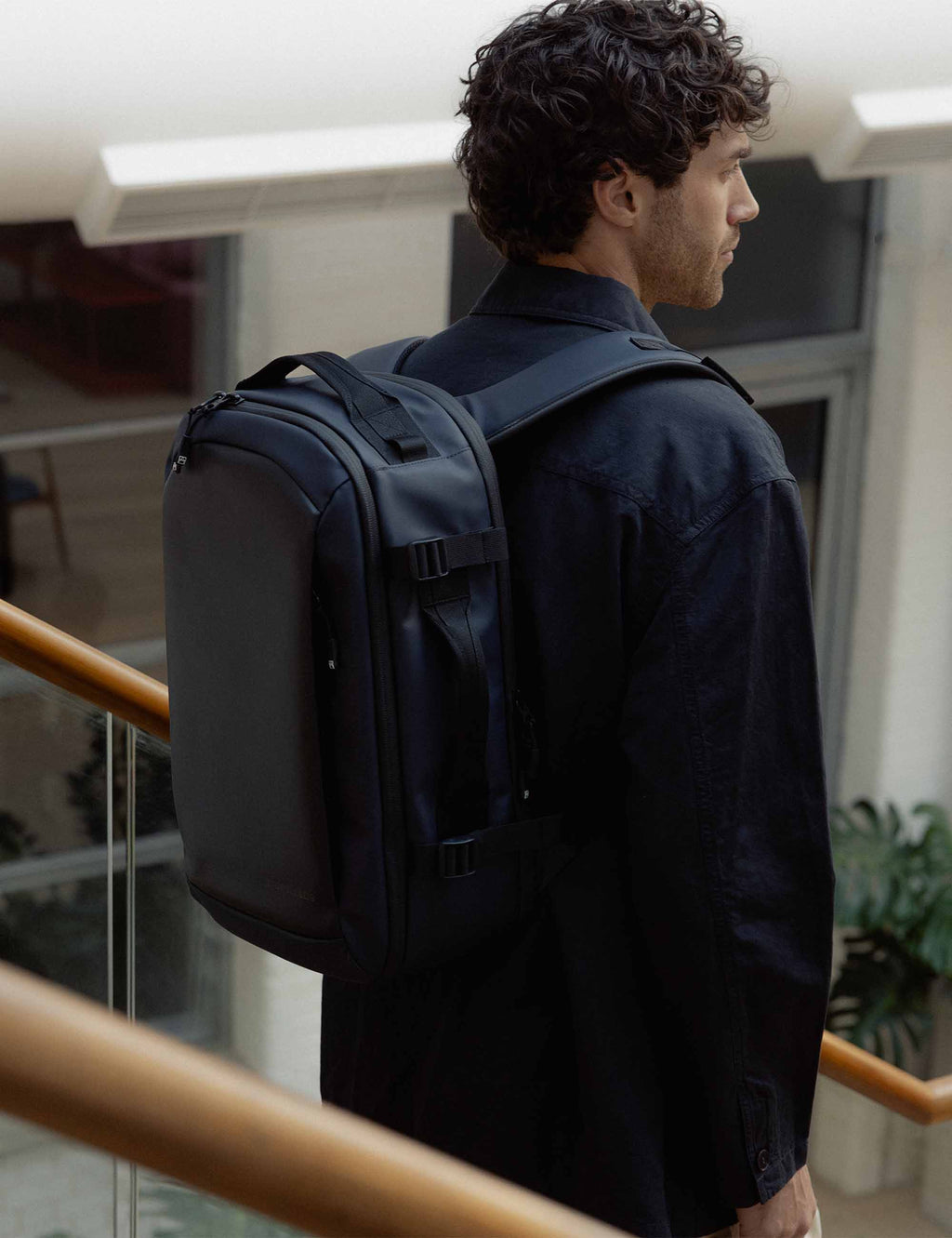 Midnight blue hybrid backpack worn on back with padded back panel and straps