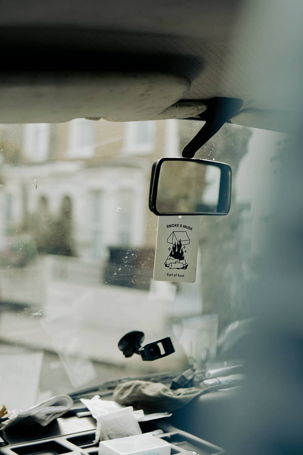 Hanging Earl of East air freshener card in a car, Smoke & Musk