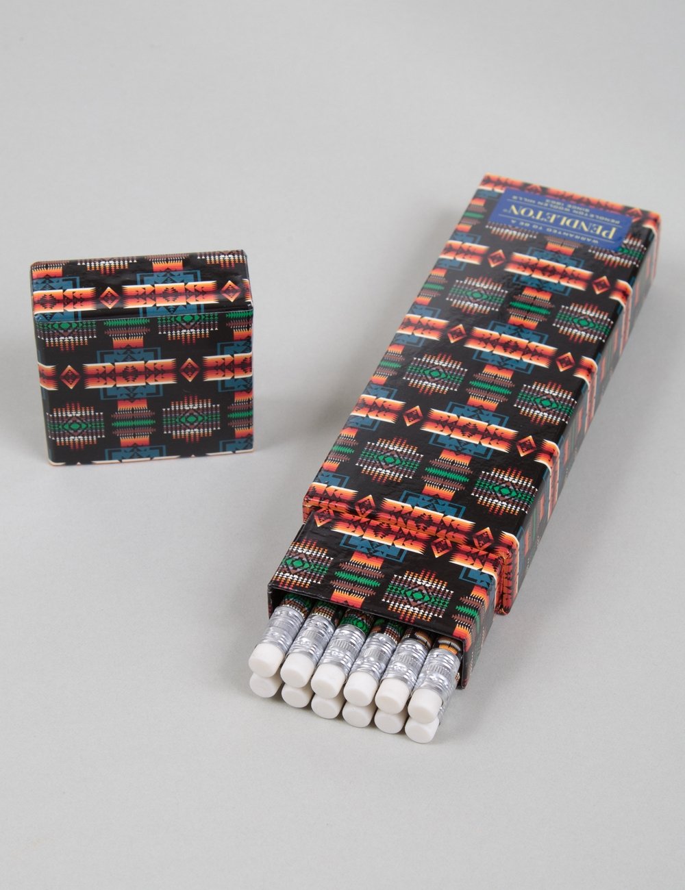 Printed pencil roll case with colored pattern and white pencils peeking out, black base