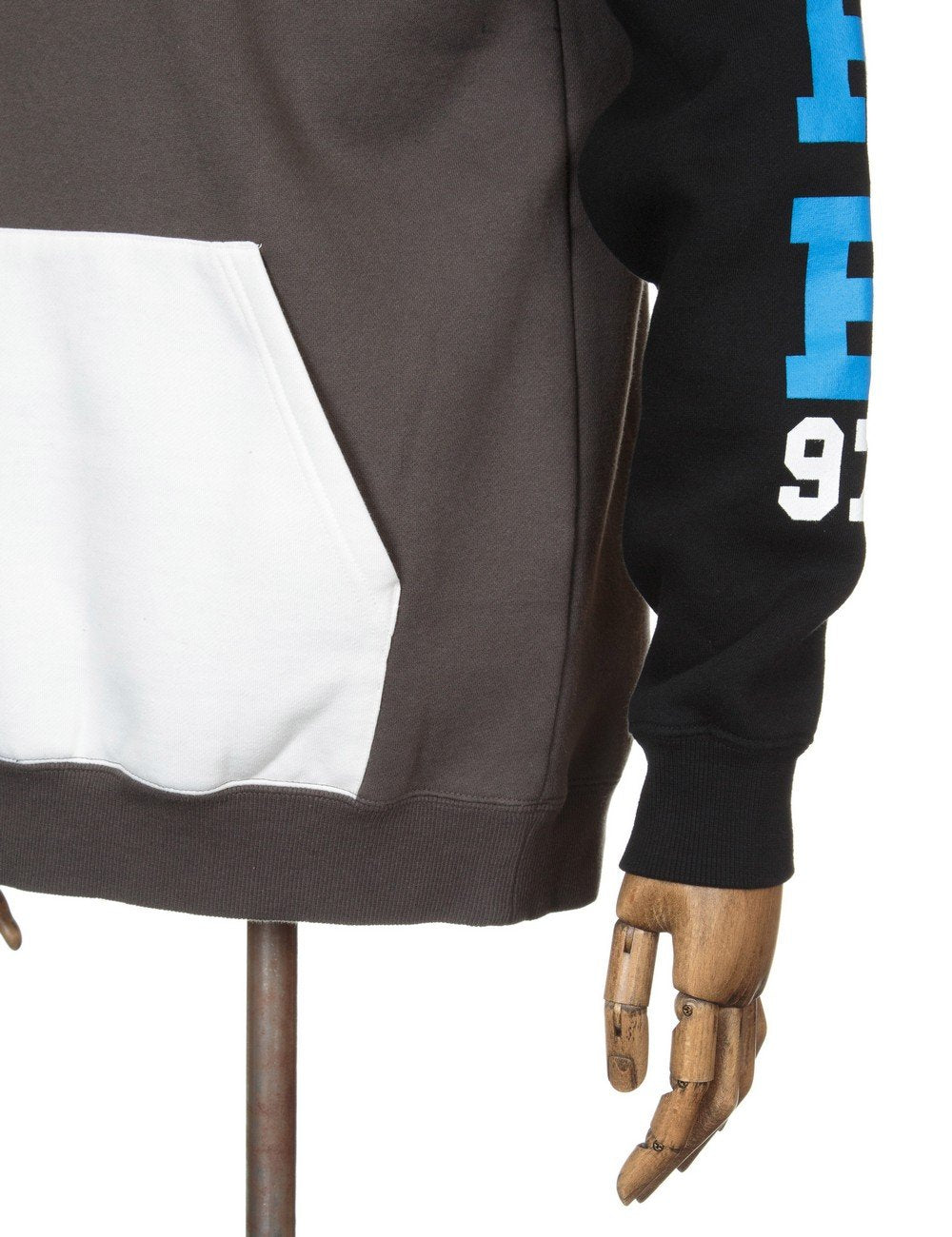 White front pocket on charcoal hooded sweatshirt with black sleeve and blue graphic