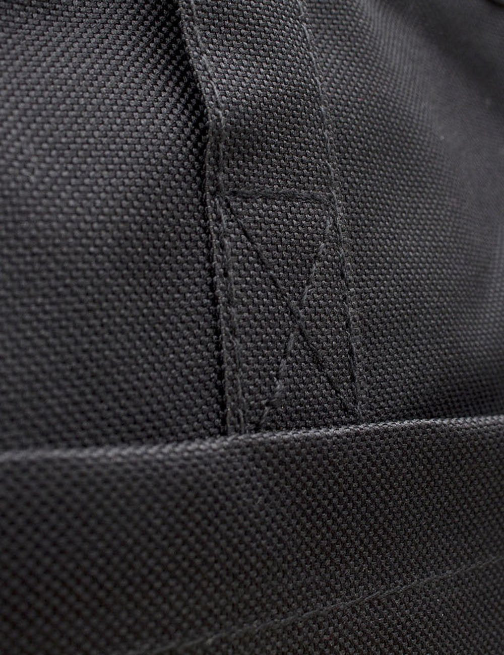 Black nylon tote bag fabric close-up with stitched panel seams