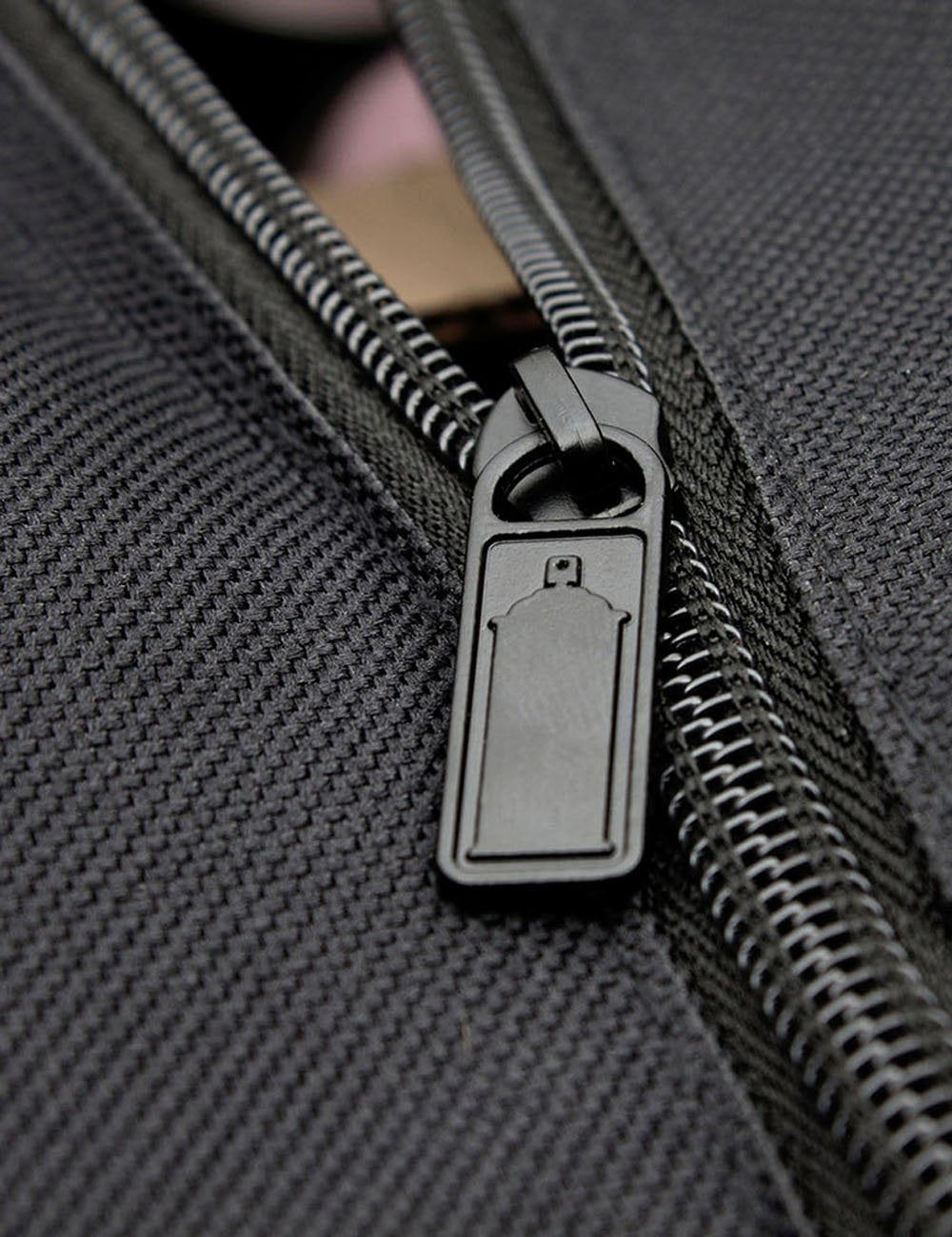 Black nylon bag zipper pull with key-shaped pull tab detail