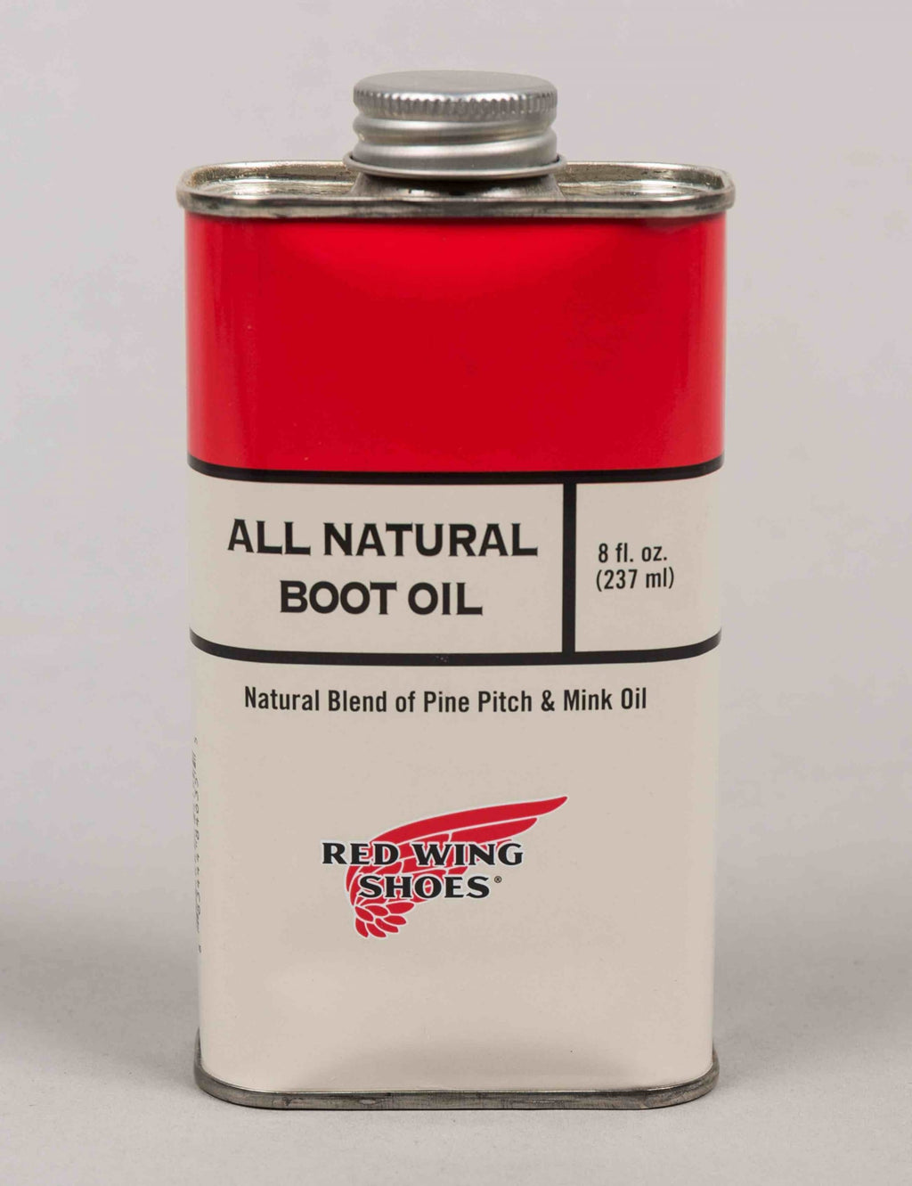 Boot oil bottle with red upper label and white lower label, silver cap