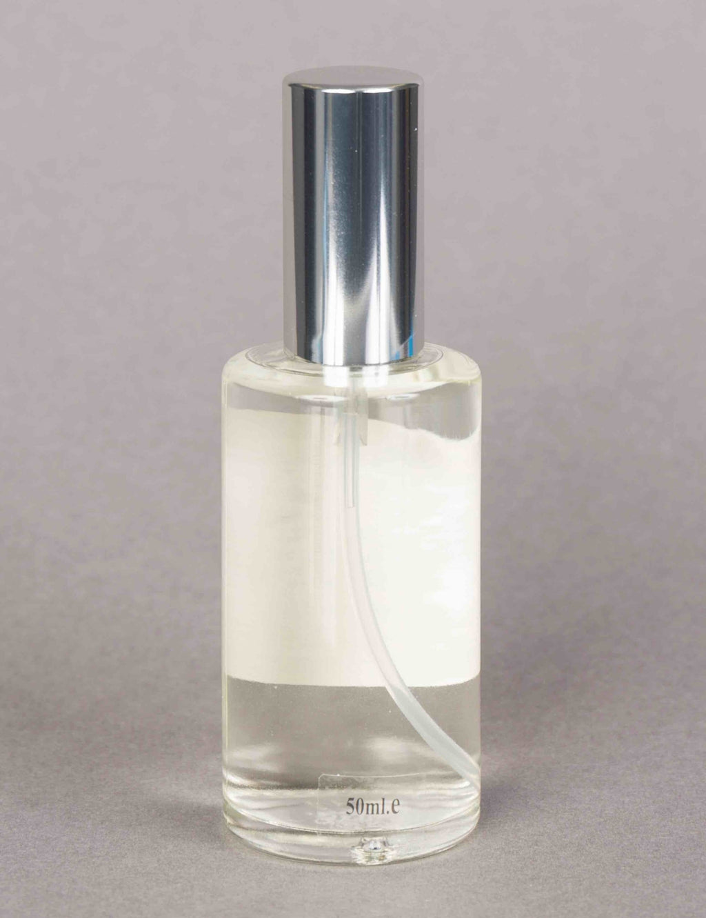 Traditional cologne spray bottle with silver cap, clear bottle and label