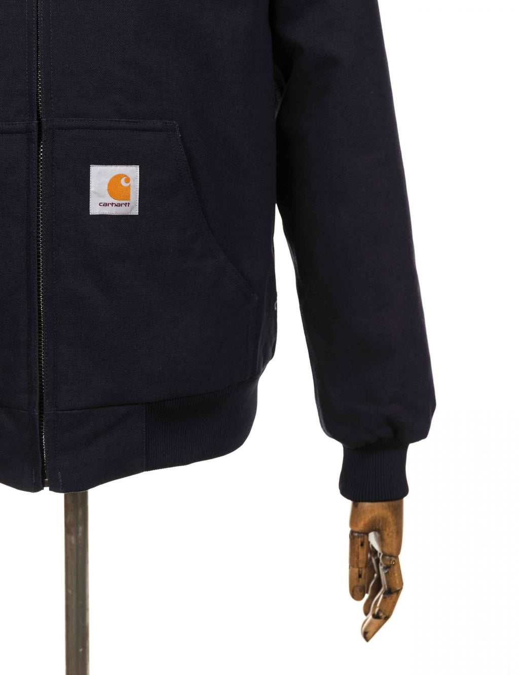 Dark navy jacket front pocket with Carhartt logo patch and zip placket
