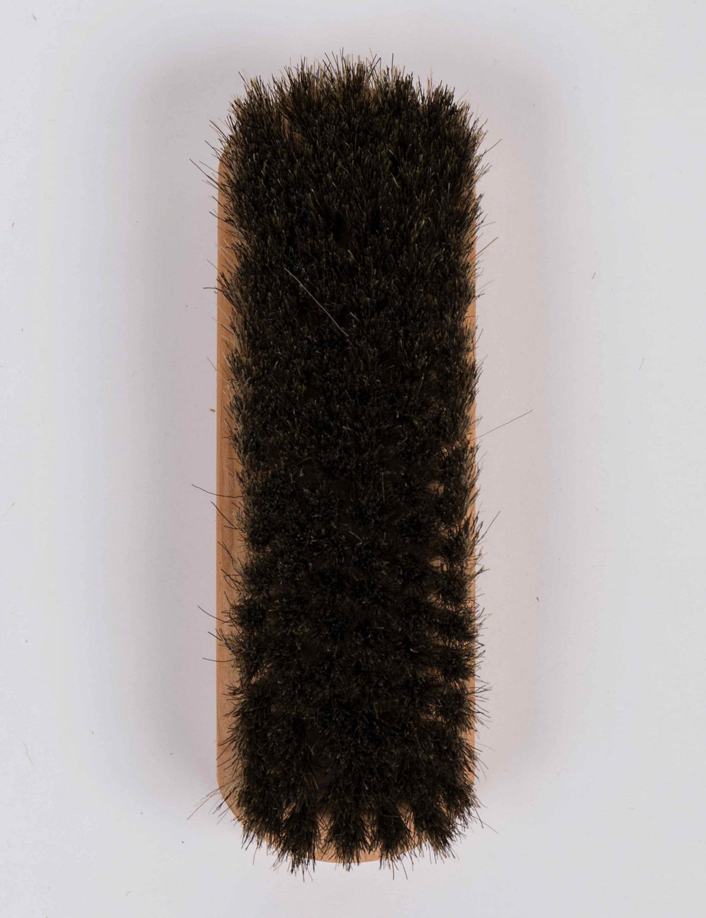 Horse hair brush with dark bristle pad and wooden backing