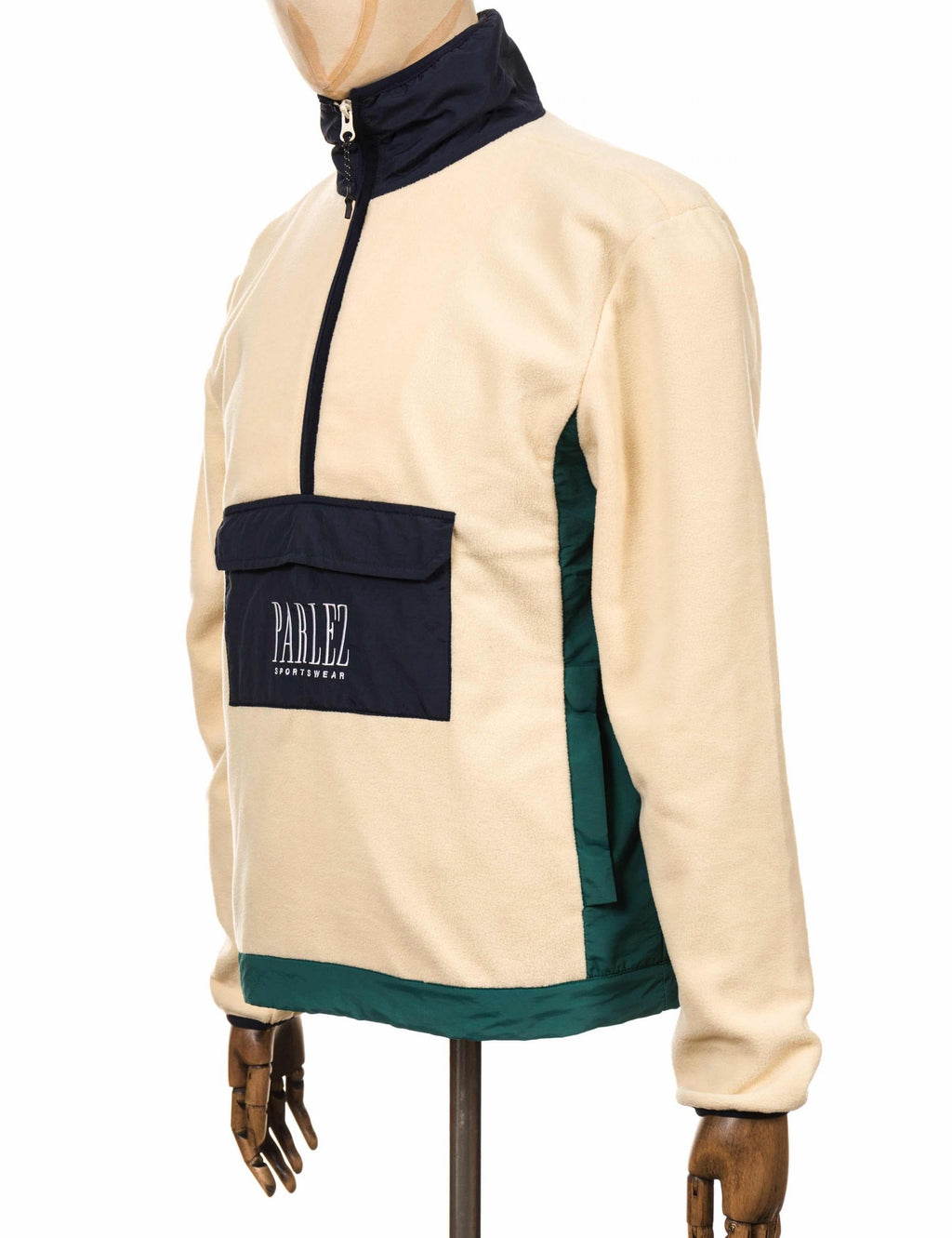 Cream fleece zip-up top with navy hood, front logo patch, and side panel
