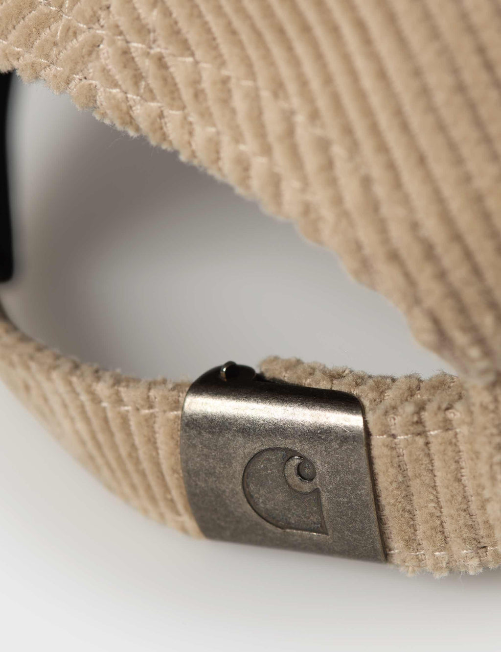 Corduroy cap strap close-up with metal buckle and C-logo emboss