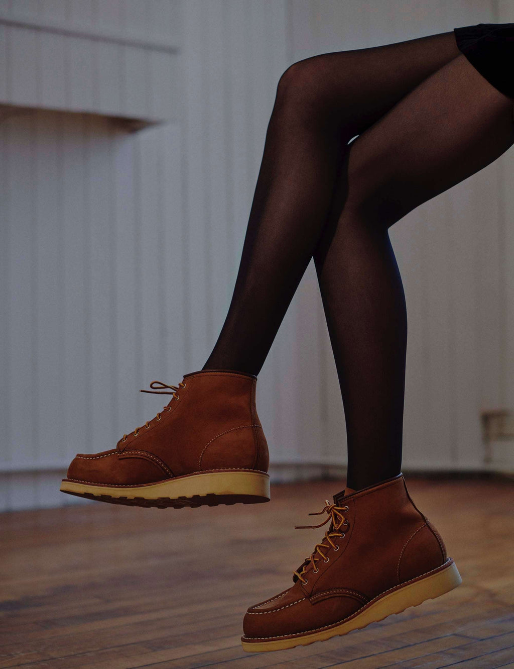 Brown moc toe lace-up ankle boots on model legs, tan sole and yellow laces