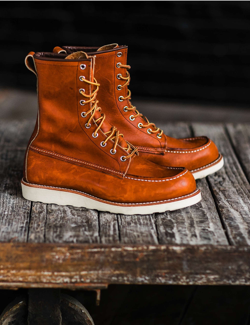 Rust-brown leather lace-up moc-toe boots with cream soles, side-by-side