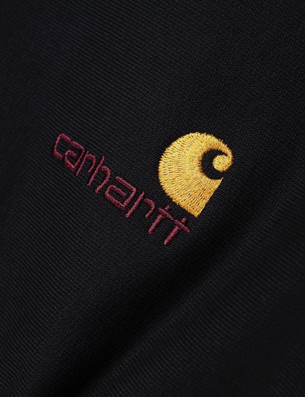 Black sweatshirt embroidery: yellow logo with red “carhartt” script