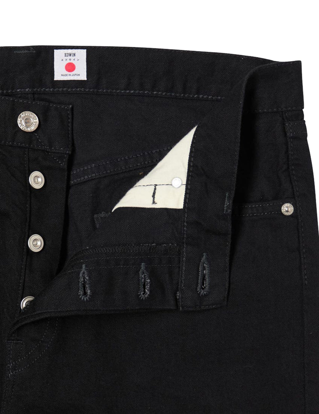 Black denim jeans close-up of button fly, coin pocket, and embroidered leg graphic