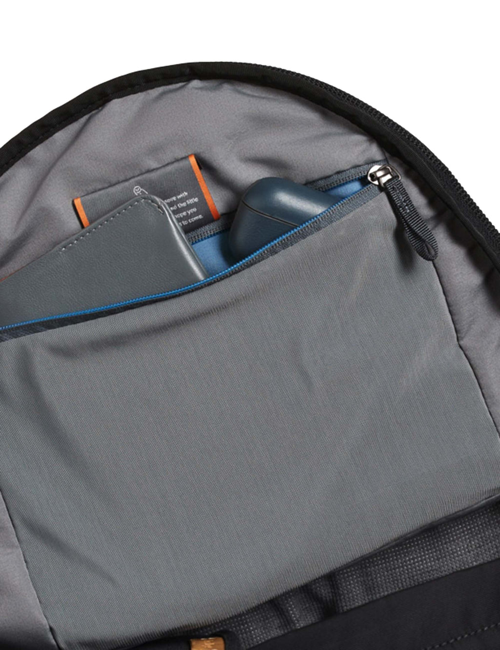 Black compact backpack interior with gray pocket panel and zipper detail