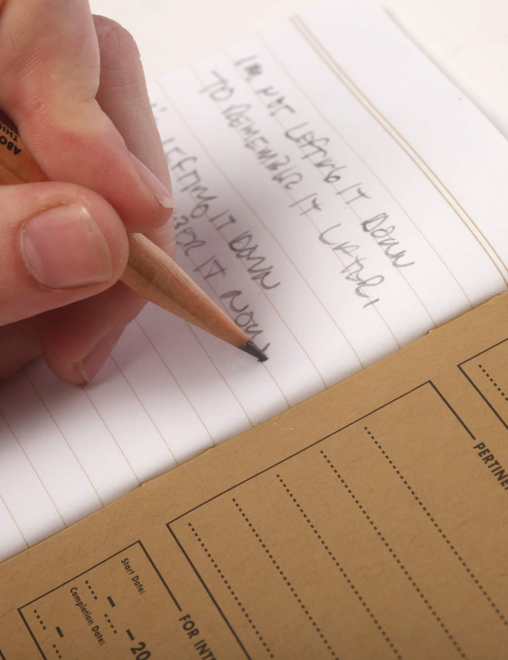 Hand holding ruled memo page with handwritten notes and margin lines.
