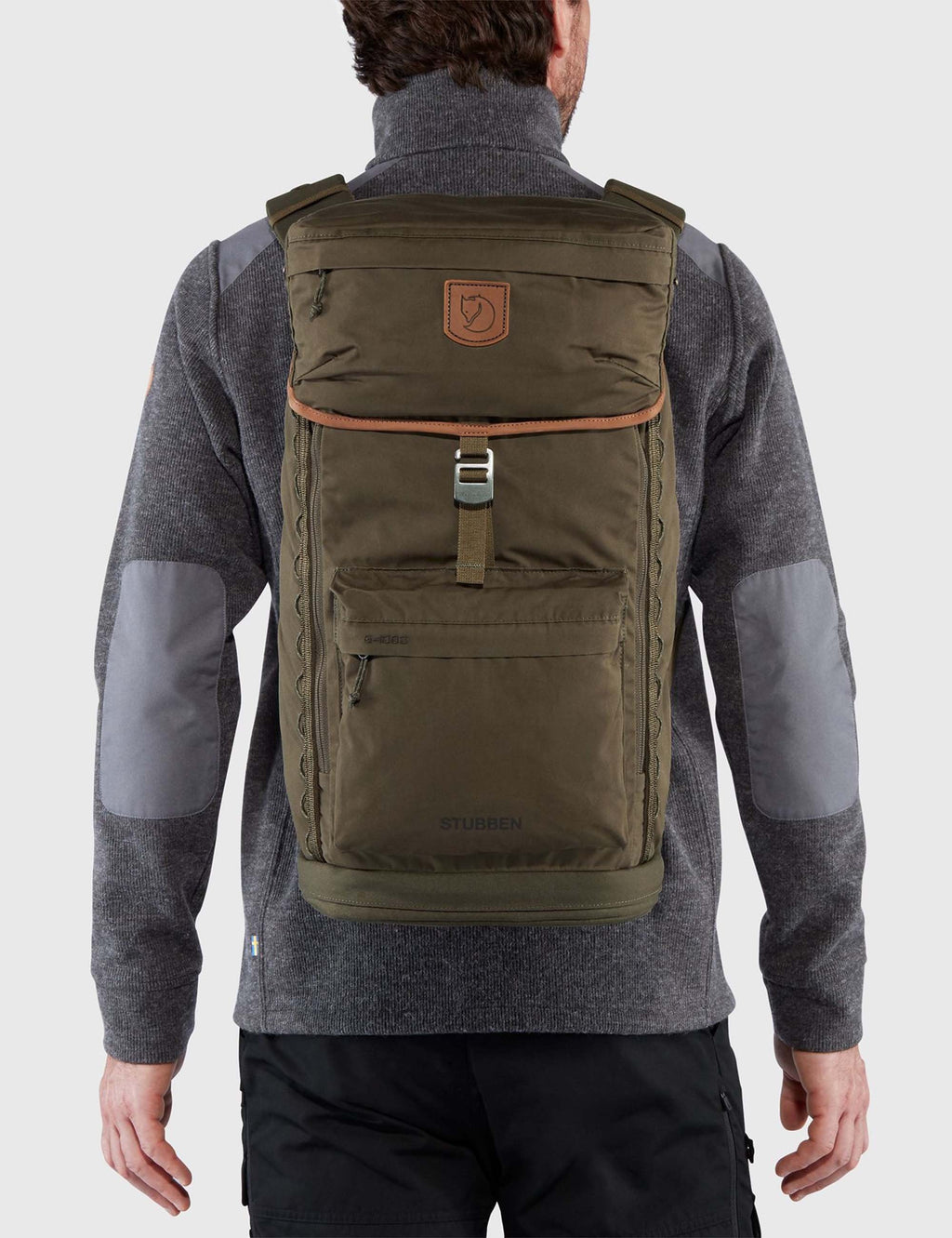 Dark olive backpack worn on back with top flap, front organizer pocket, and logo.