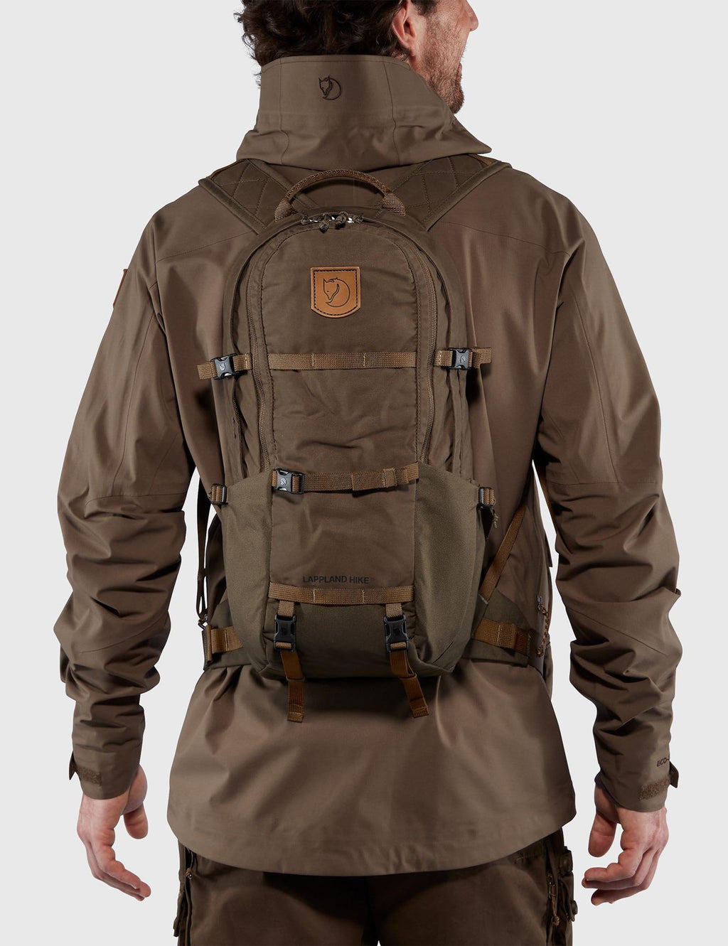 Dark olive hiking backpack worn on back with padded shoulder straps