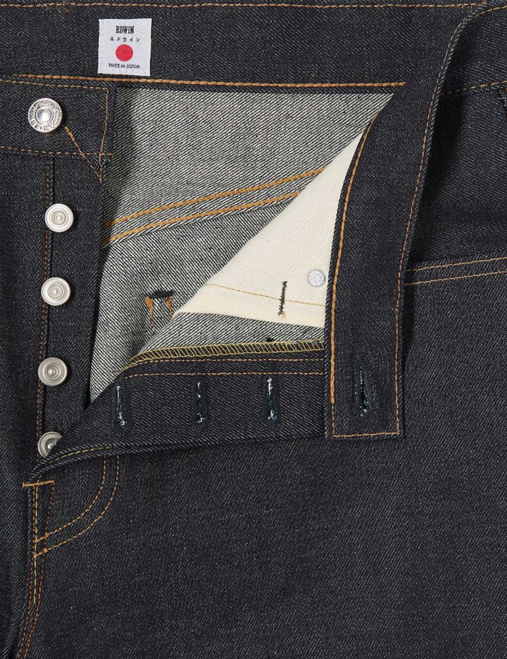 Selvedge denim pocket and button placket detail with contrast orange stitching