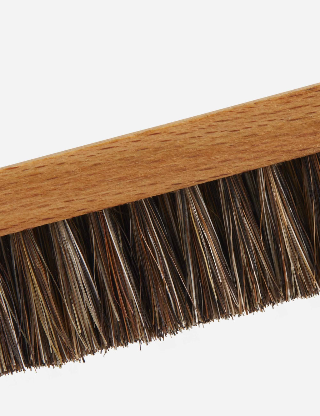 Close-up of stiff dark horse-hair bristles on wooden welt cleaning brush
