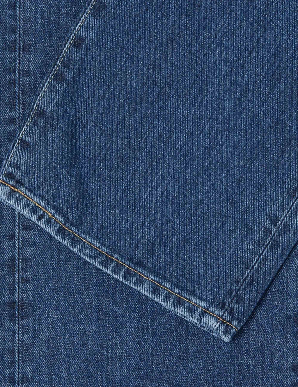 Blue denim jeans hem with stitched cuff and diagonal seam detail.