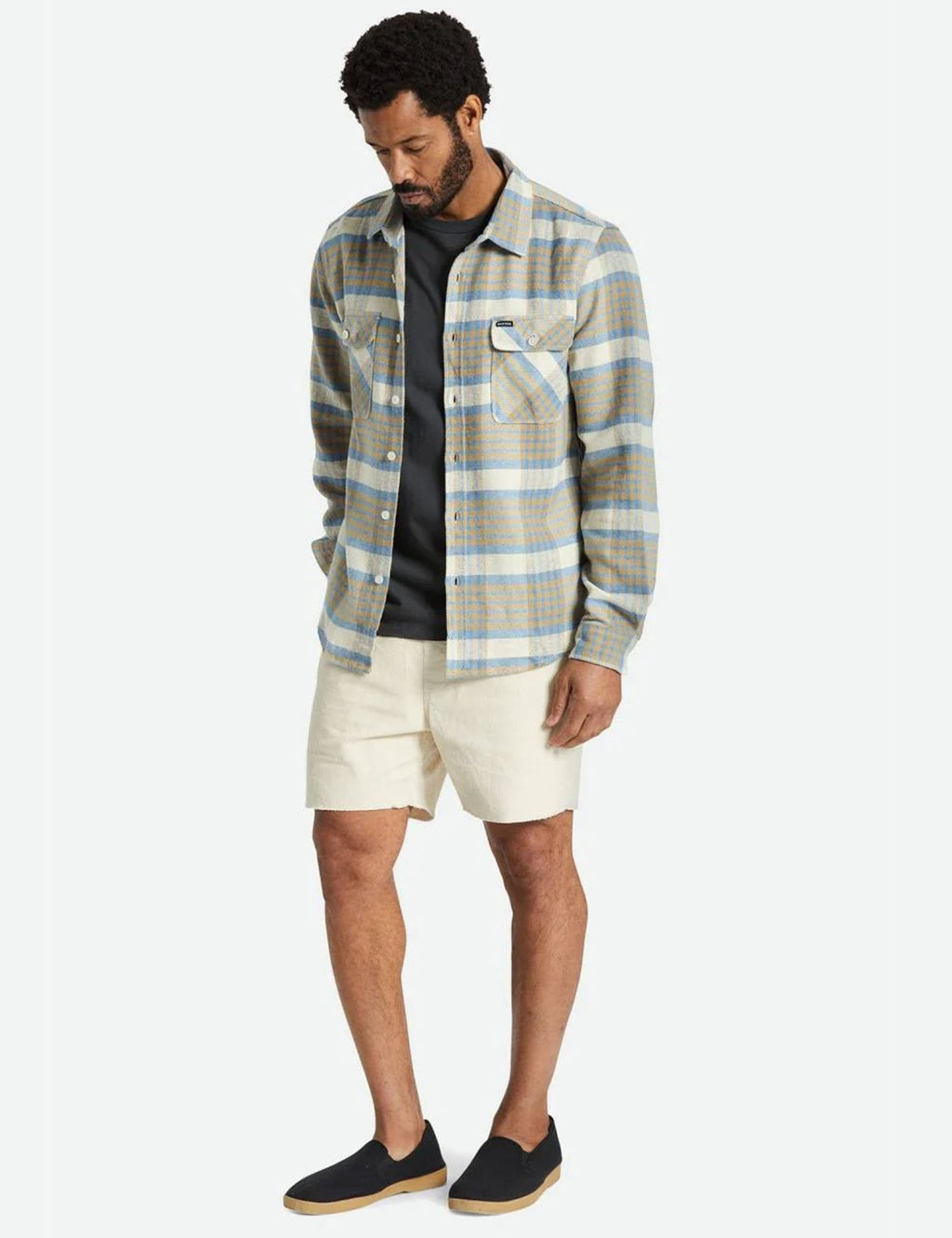 Plaid flannel button-up shirt in blue and sand, chest flap pockets, worn with shorts