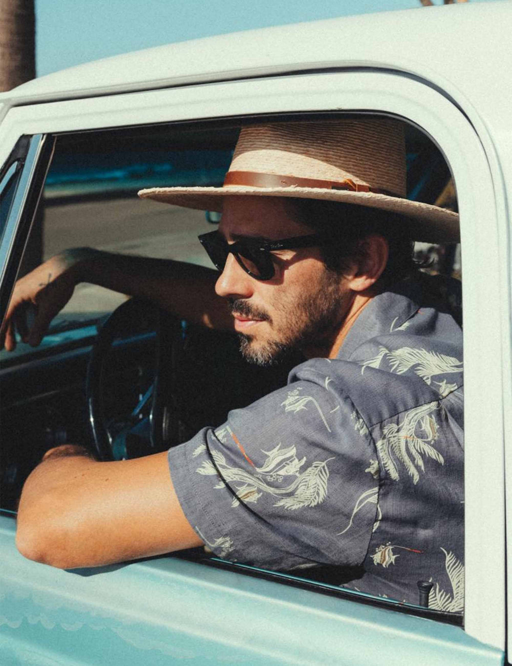 Dark gray-blue short-sleeve button-up shirt with green dinosaur print