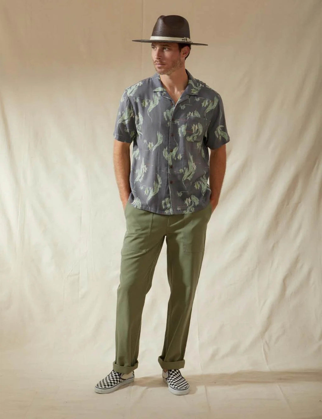 Dark gray-blue short-sleeve button-up shirt with green dinosaur print and point collar