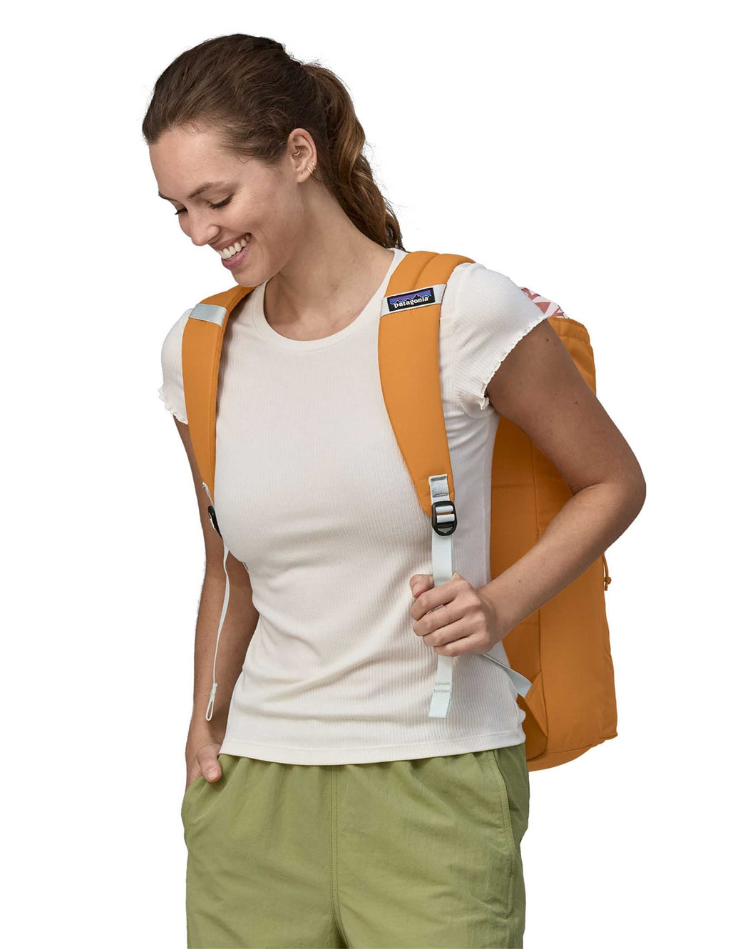 Golden caramel 25L backpack worn by person, adjustable shoulder straps visible