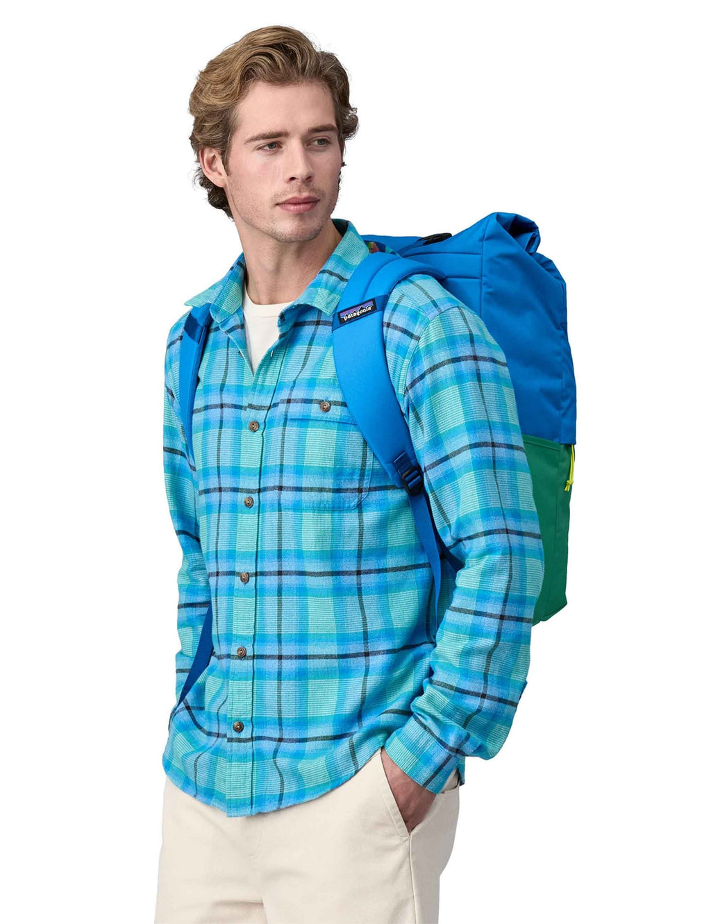 Roll-top backpack worn on back with blue roll-top, green base, and shoulder straps