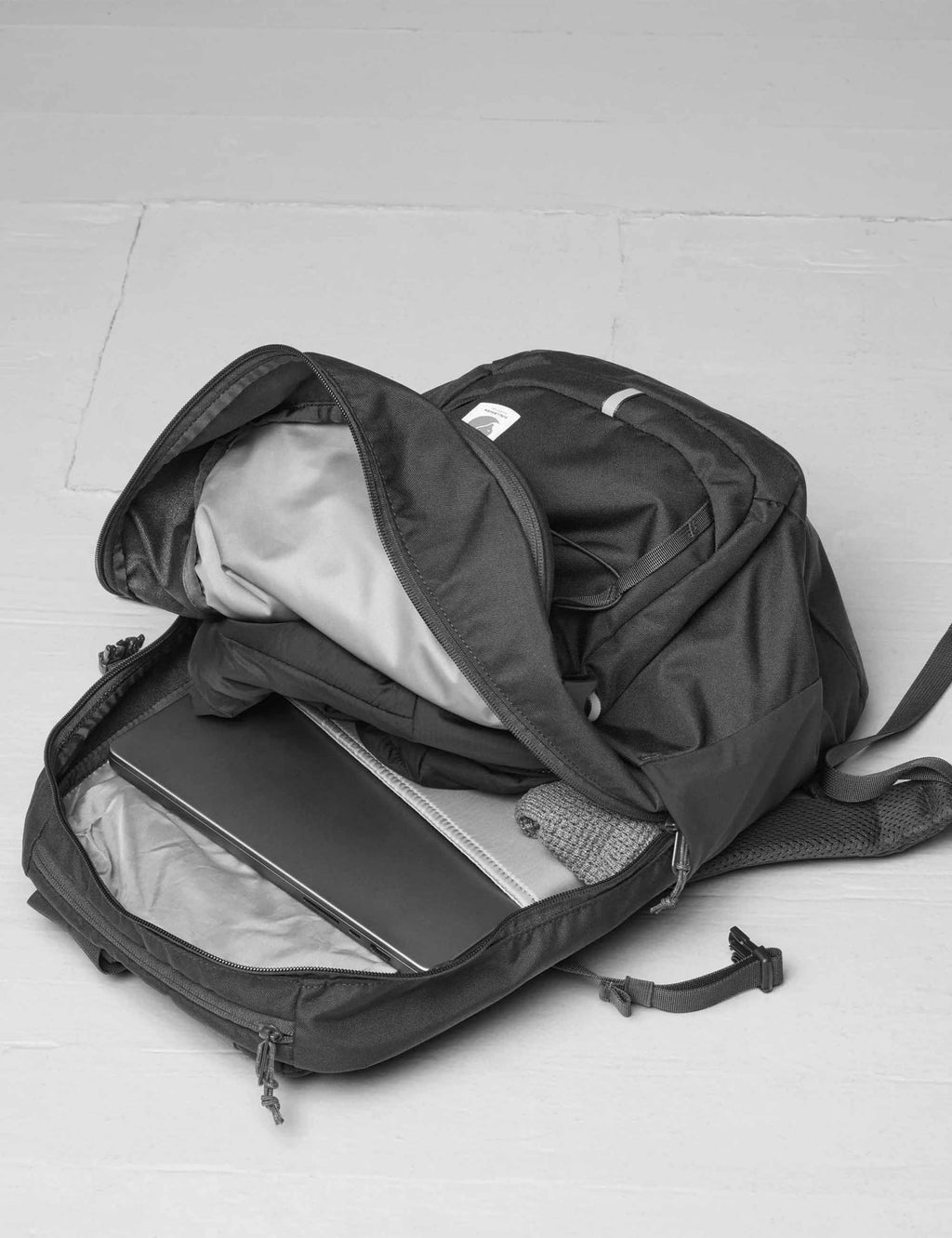 Navy 28L backpack open with gray lining, mesh pockets, and zipper organizer