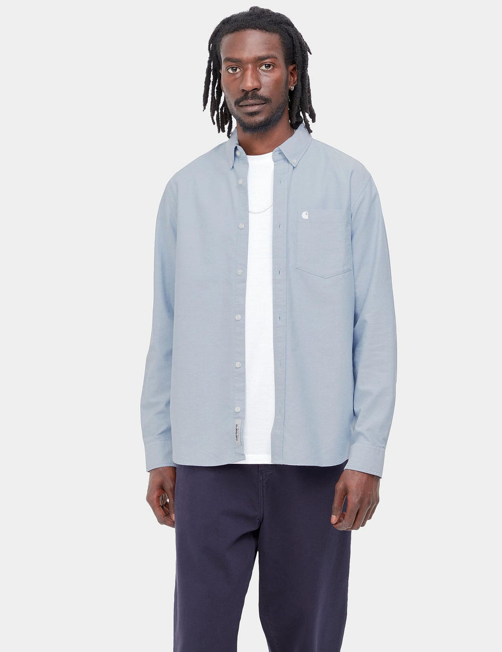Light blue button-up shirt with collar and chest pocket, worn over white tee
