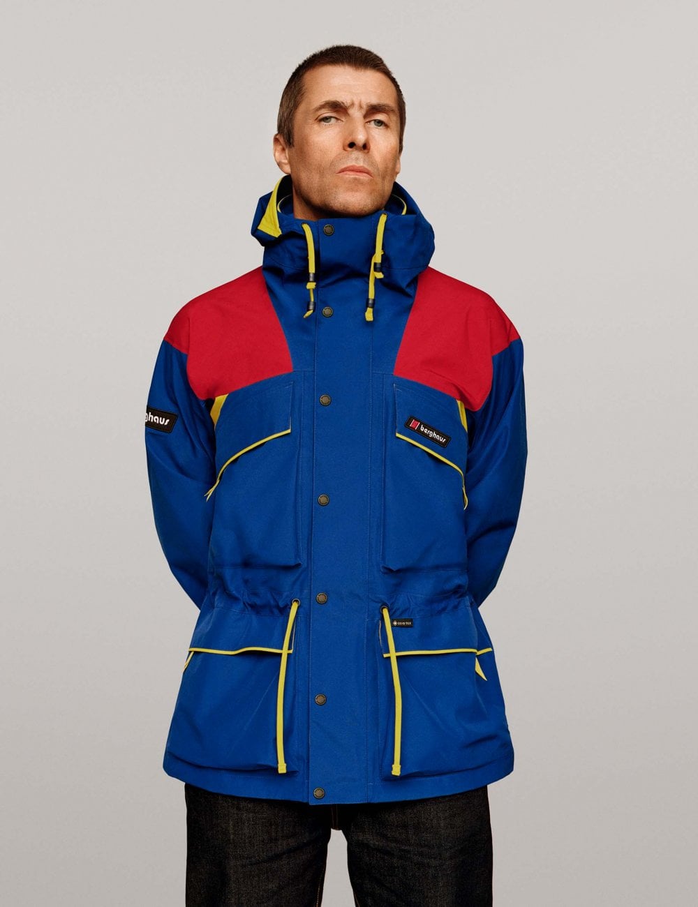 Waterproof jacket with hood, blue with red shoulders, yellow-trim drawcords and pockets