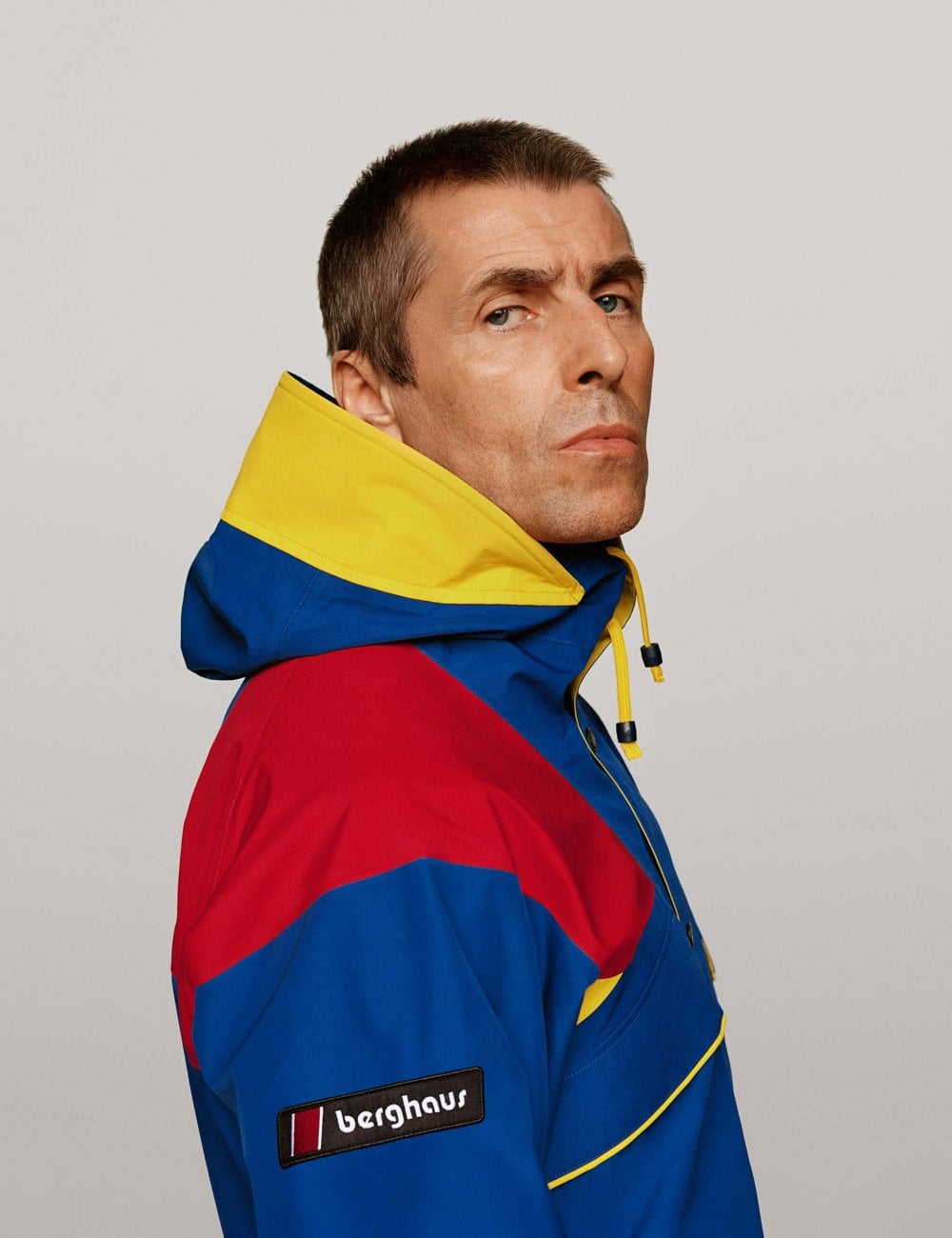 Waterproof jacket with hood, blue and red color-block panels, yellow trim