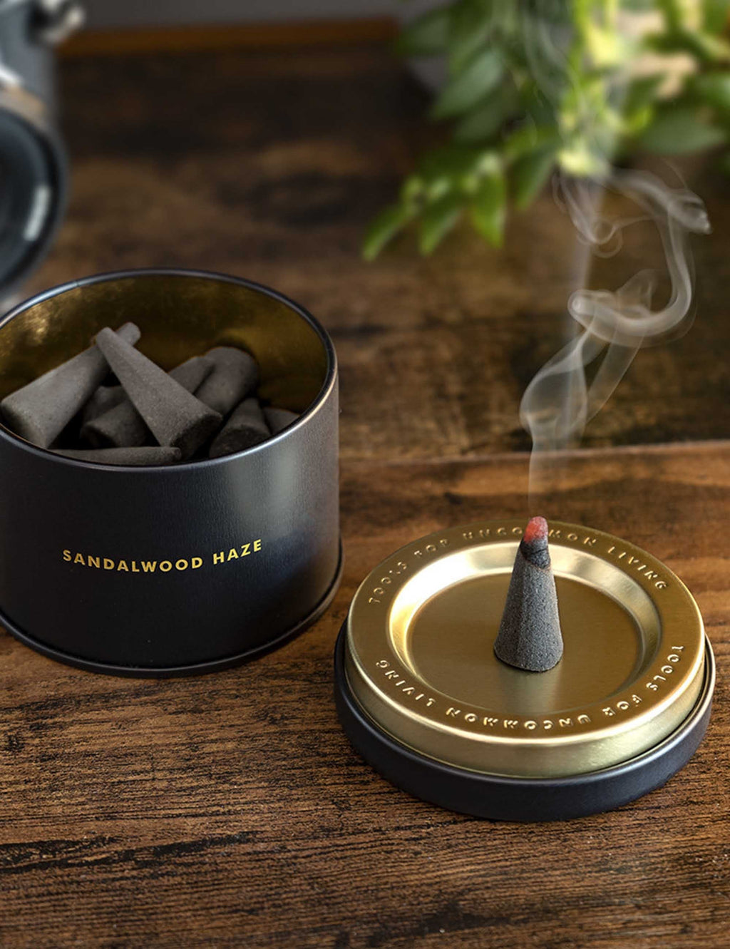 Sandalwood incense cones in a metal tin with open lid and smoke rising