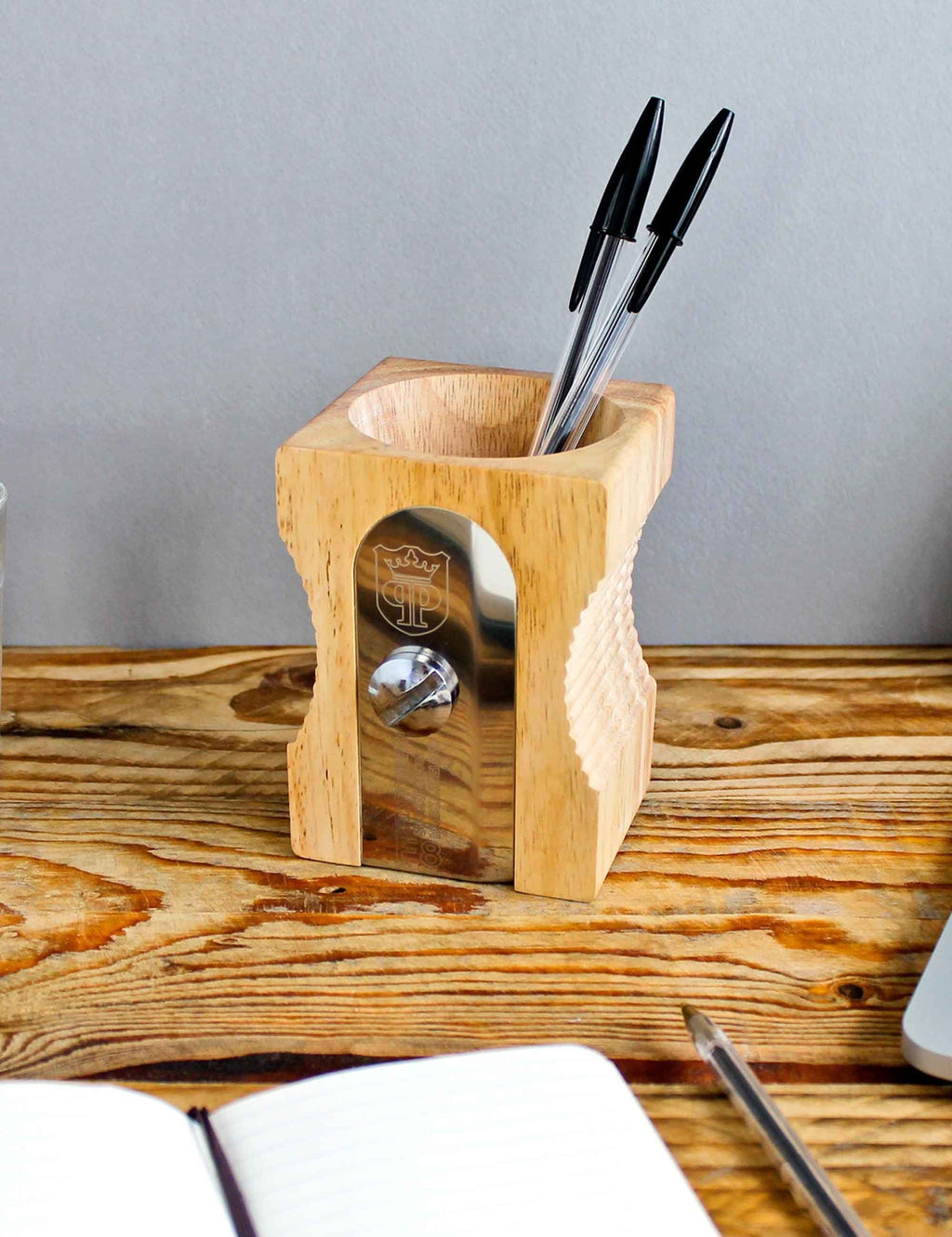 Light wood desk tidy with pencil slots and metal sharpener window on desk