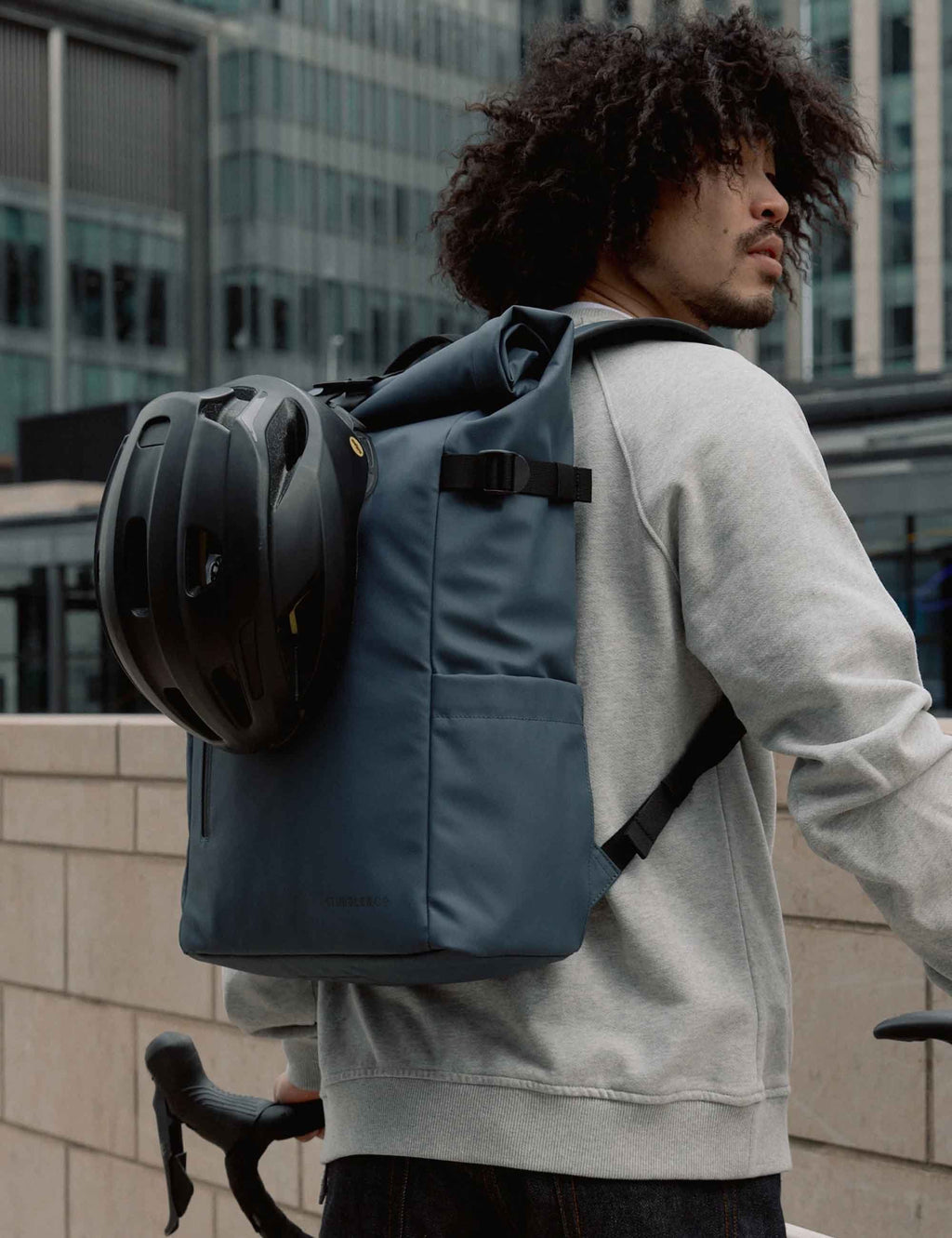 Tasmin Blue roll-top backpack with rolled top closure and front webbing strap