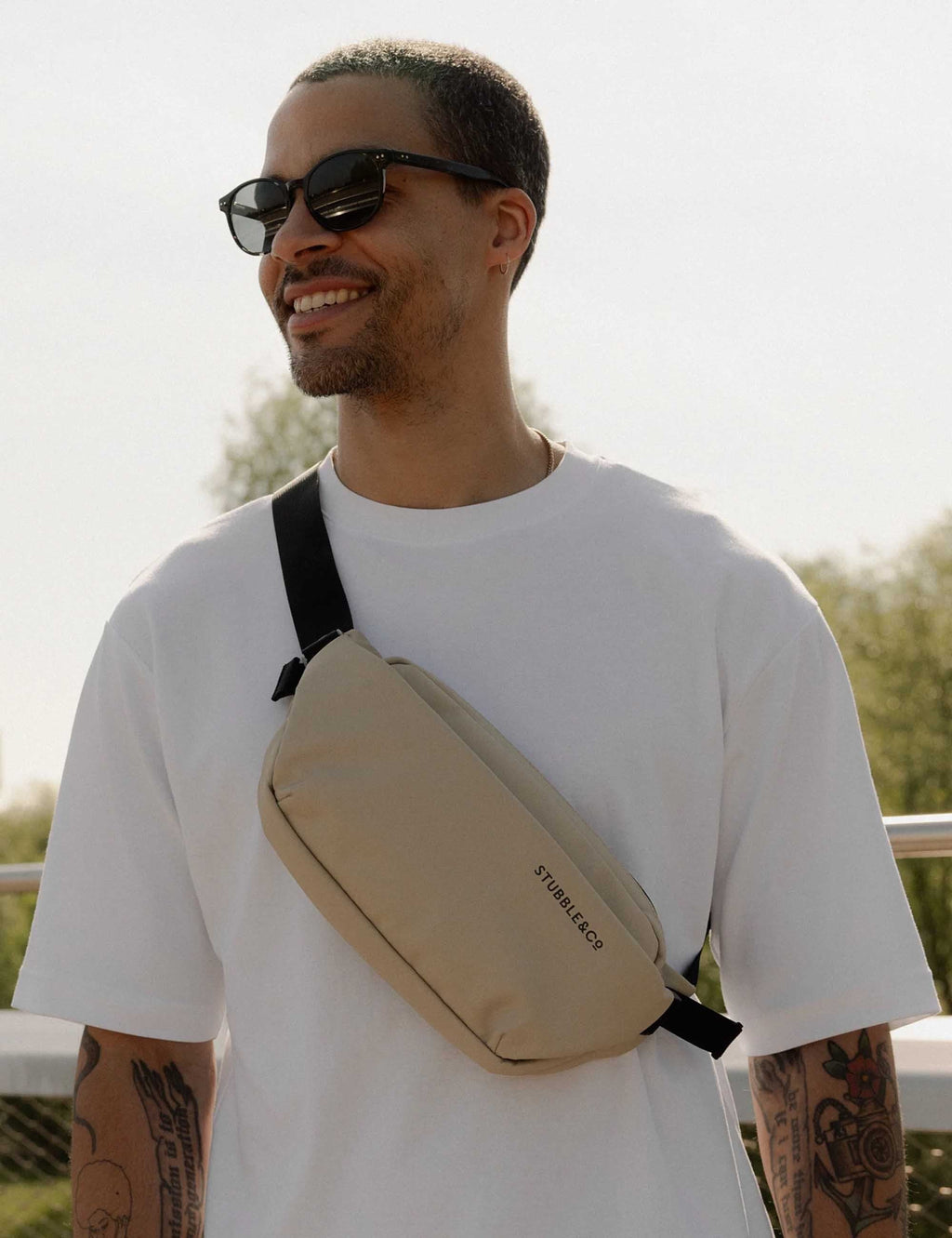 Sand crossbody sling bag with black strap and STUBBLE&E&O logo, zip top