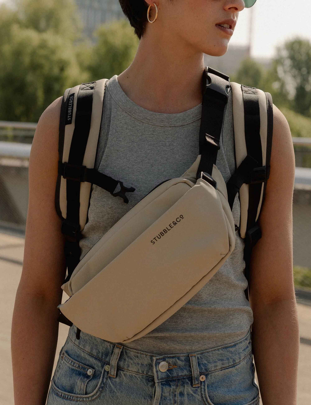 Sand crossbody sling bag with black shoulder strap and zippered compartment