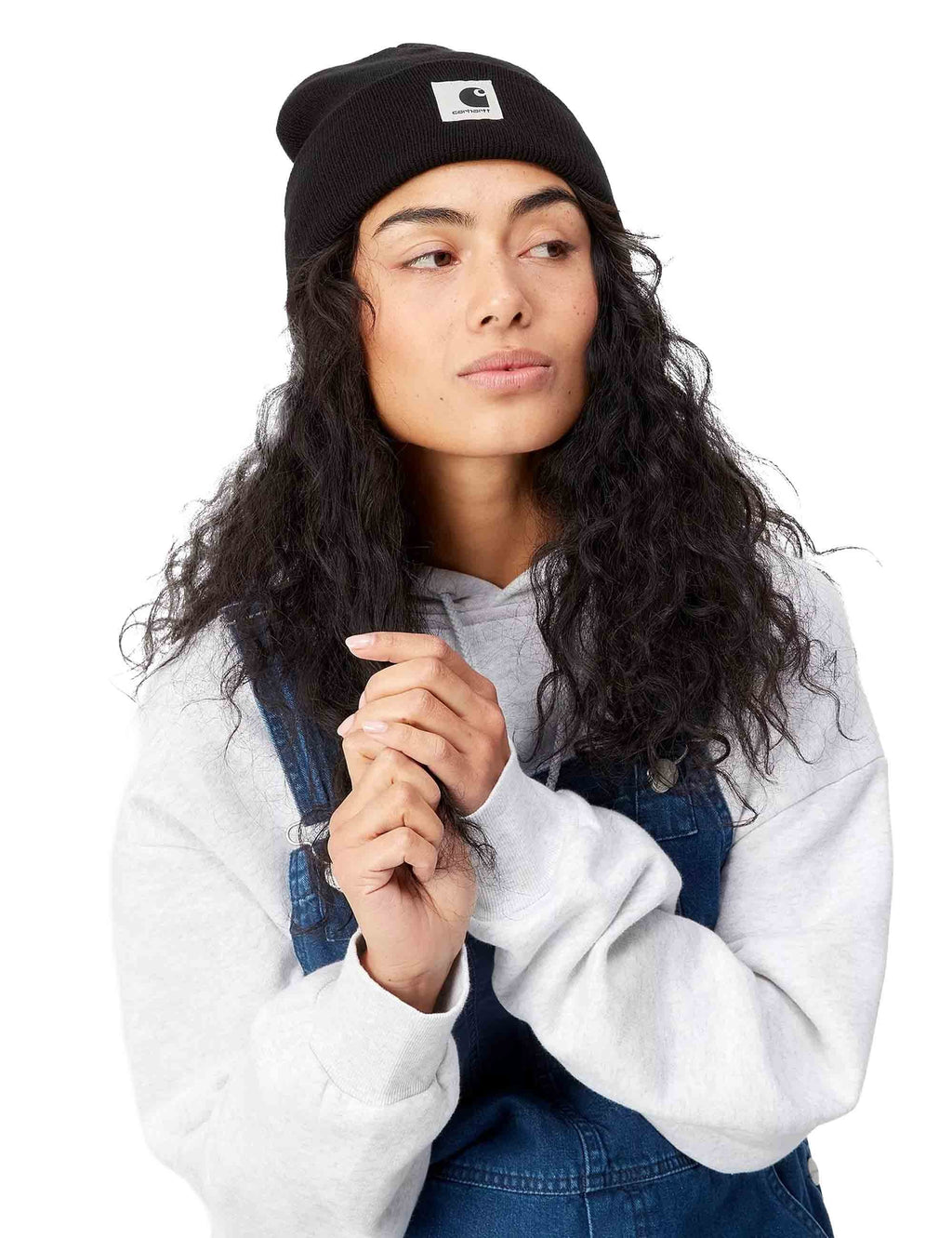 Black beanie hat worn on head with ribbed cuff and Carhartt logo patch