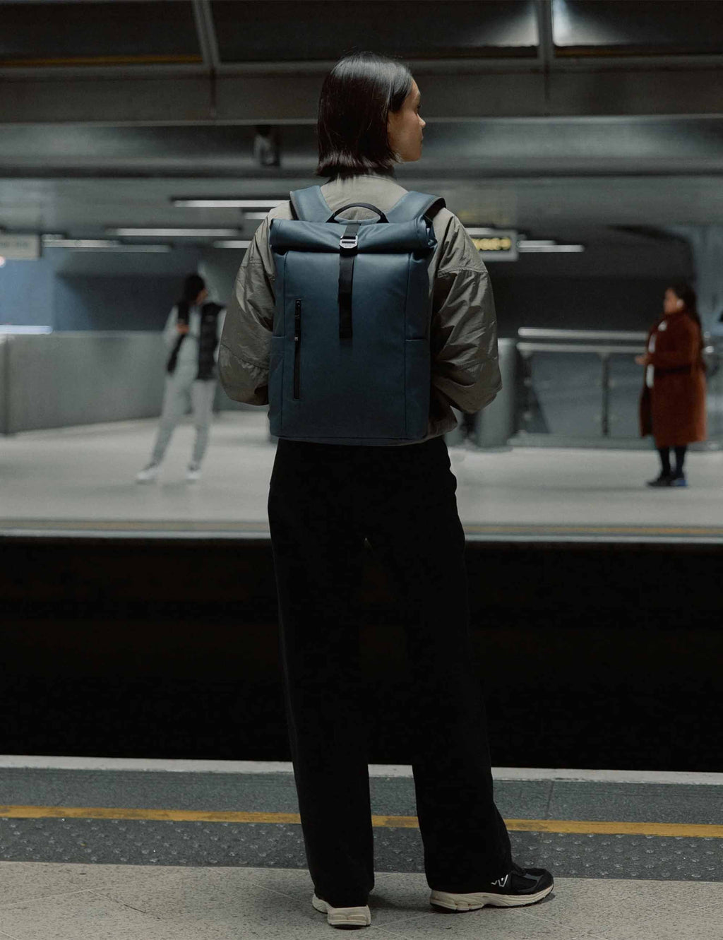 Tasmin Blue roll-top backpack worn on back with padded straps and back panel.