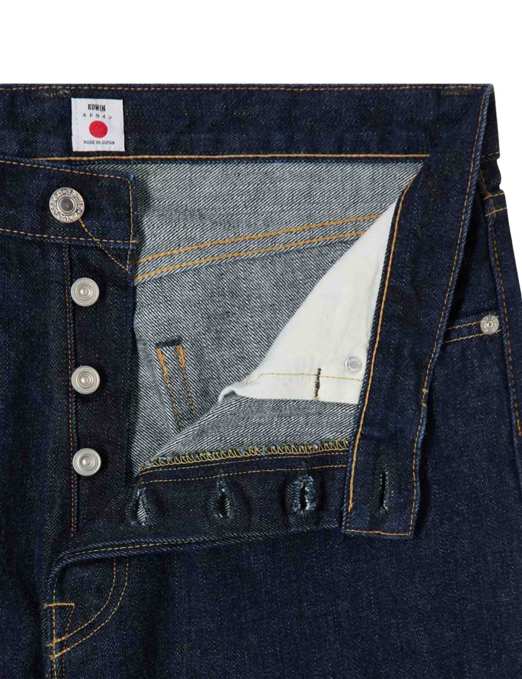 Blue selvedge jeans detail: coin pocket, metal buttons, contrast pocket lining
