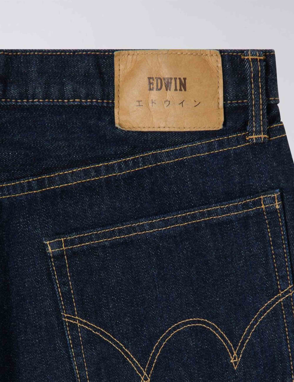 Blue selvedge jeans waistband leather brand patch with stitched back pocket design