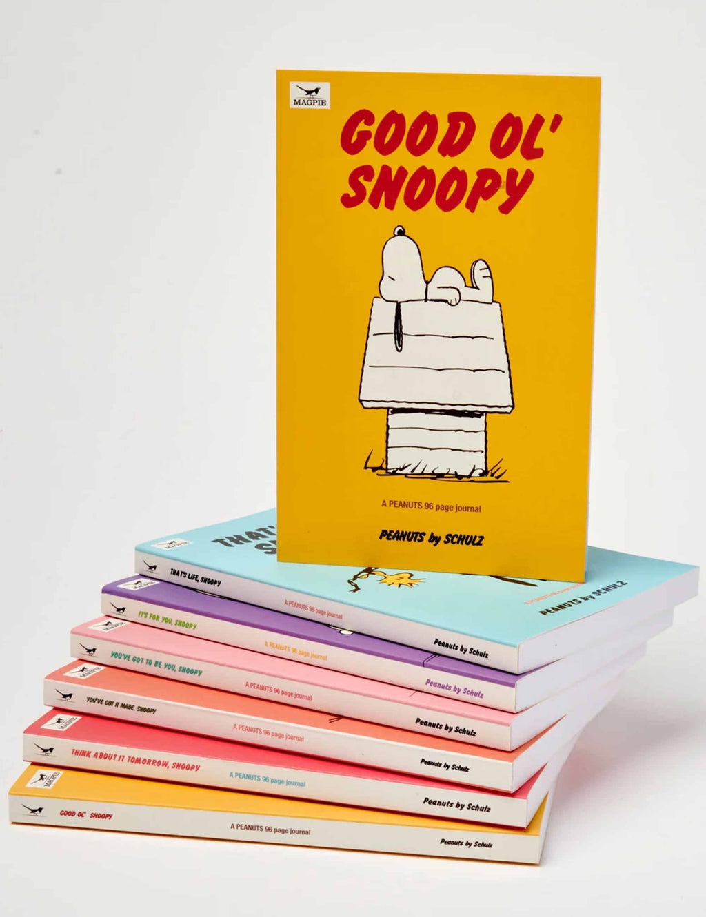 Stack of Good Ol' Snoopy journals with yellow covers and Snoopy reading on the top book