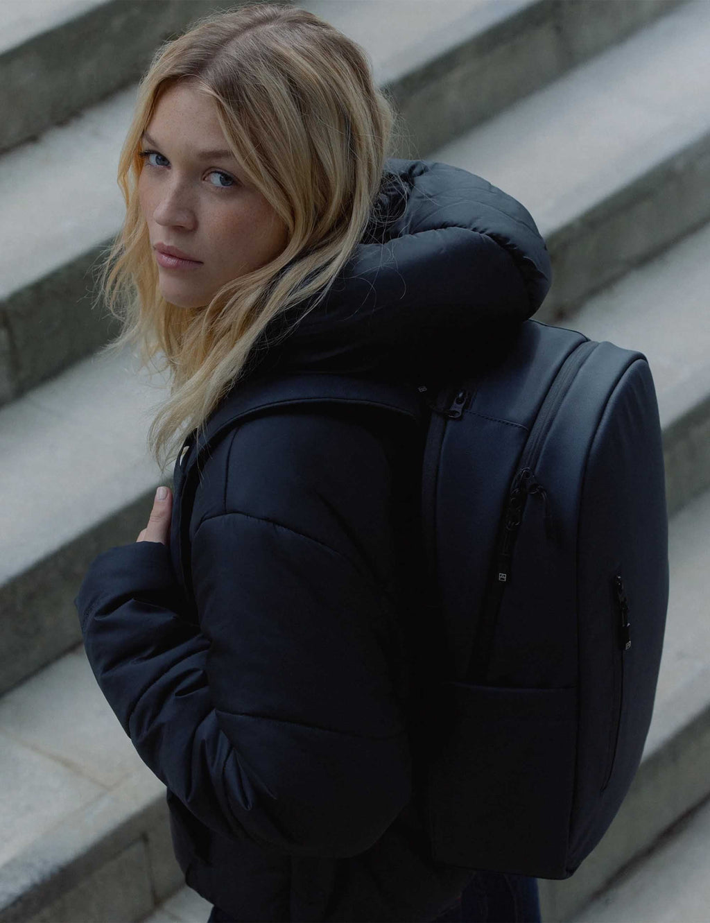 Midnight blue 20L backpack with side profile, padded straps, and zip accents