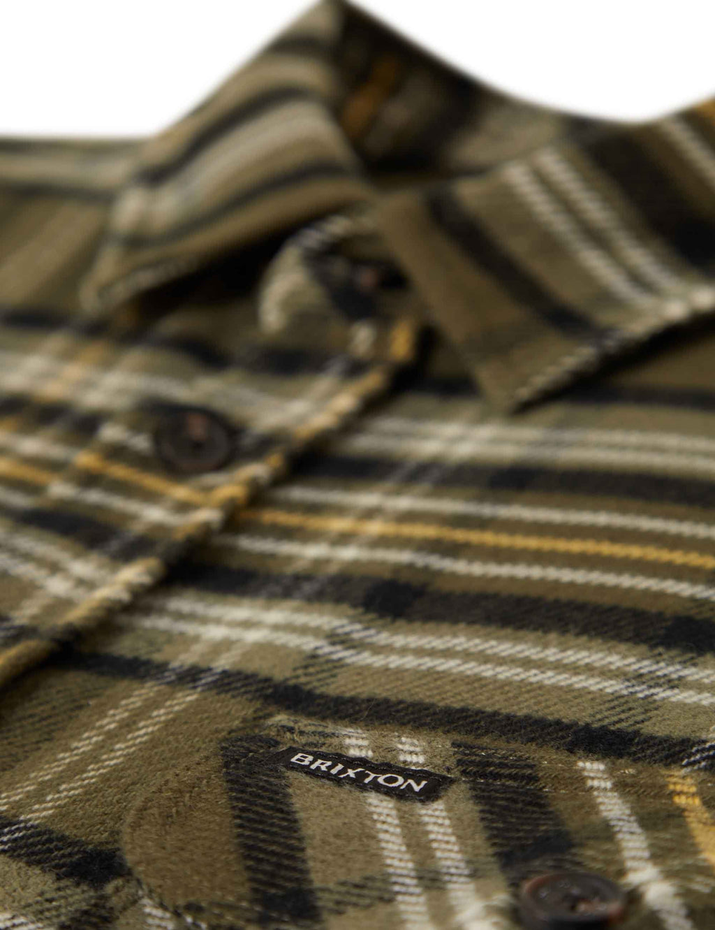 Plaid flannel shirt close-up with button front and stitched logo patch