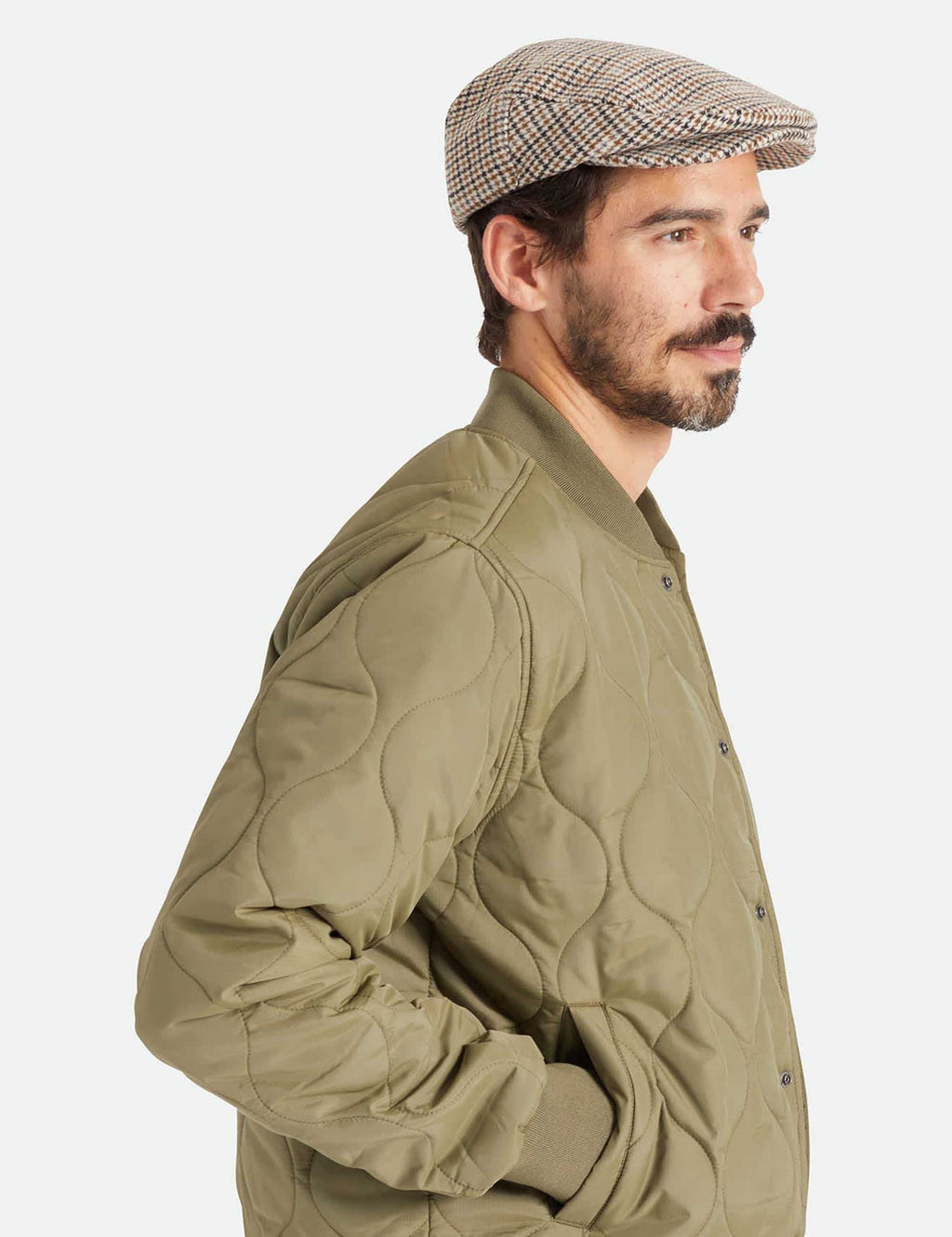 Hooligan flat cap on a model, houndstooth check in off-white with navy and tan