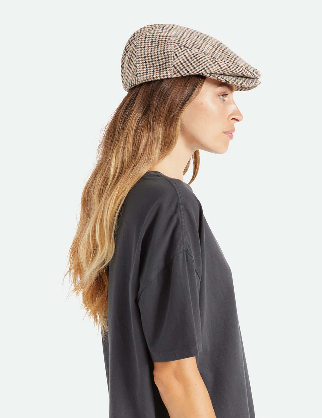 Hooligan flat cap on a model, beige houndstooth check with navy and tan