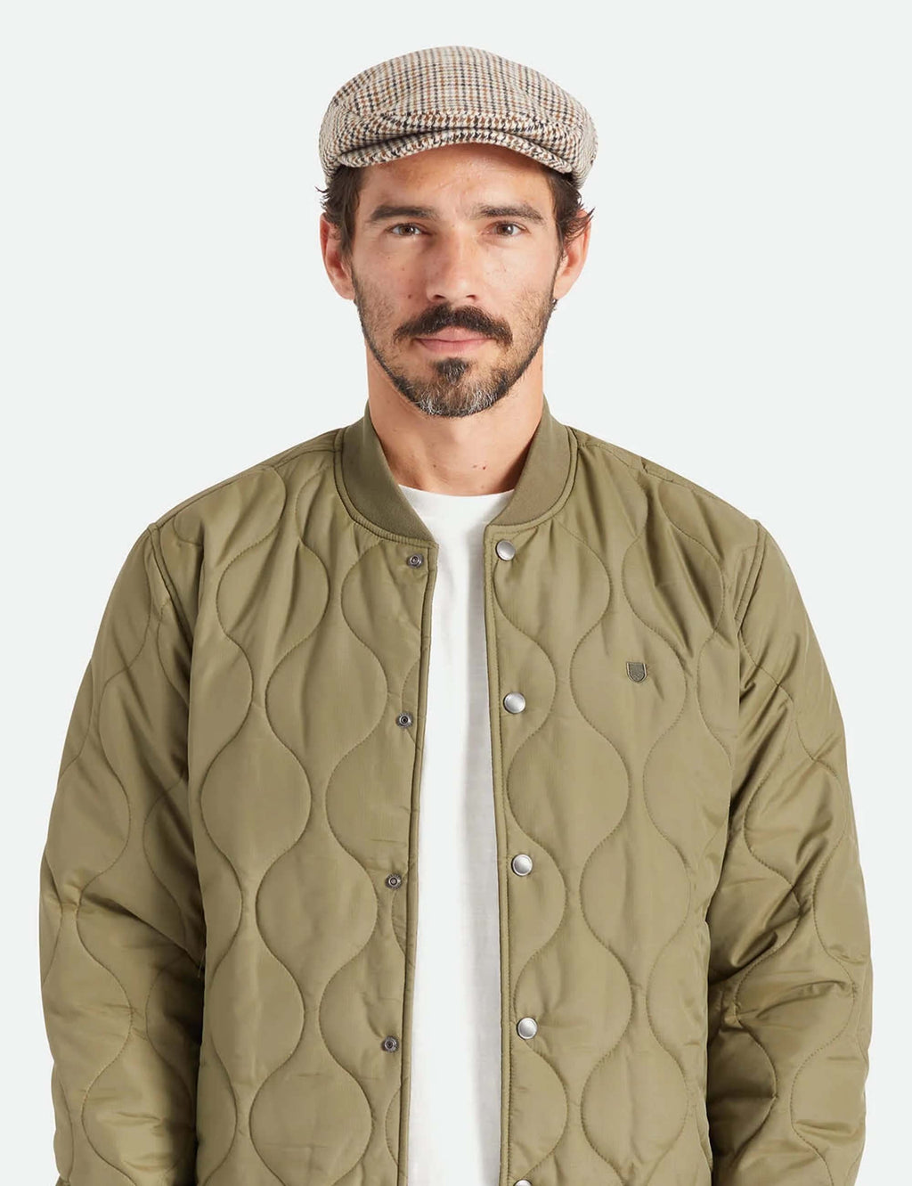 Hooligan flat cap on a model, off-white houndstooth with navy and tan pattern