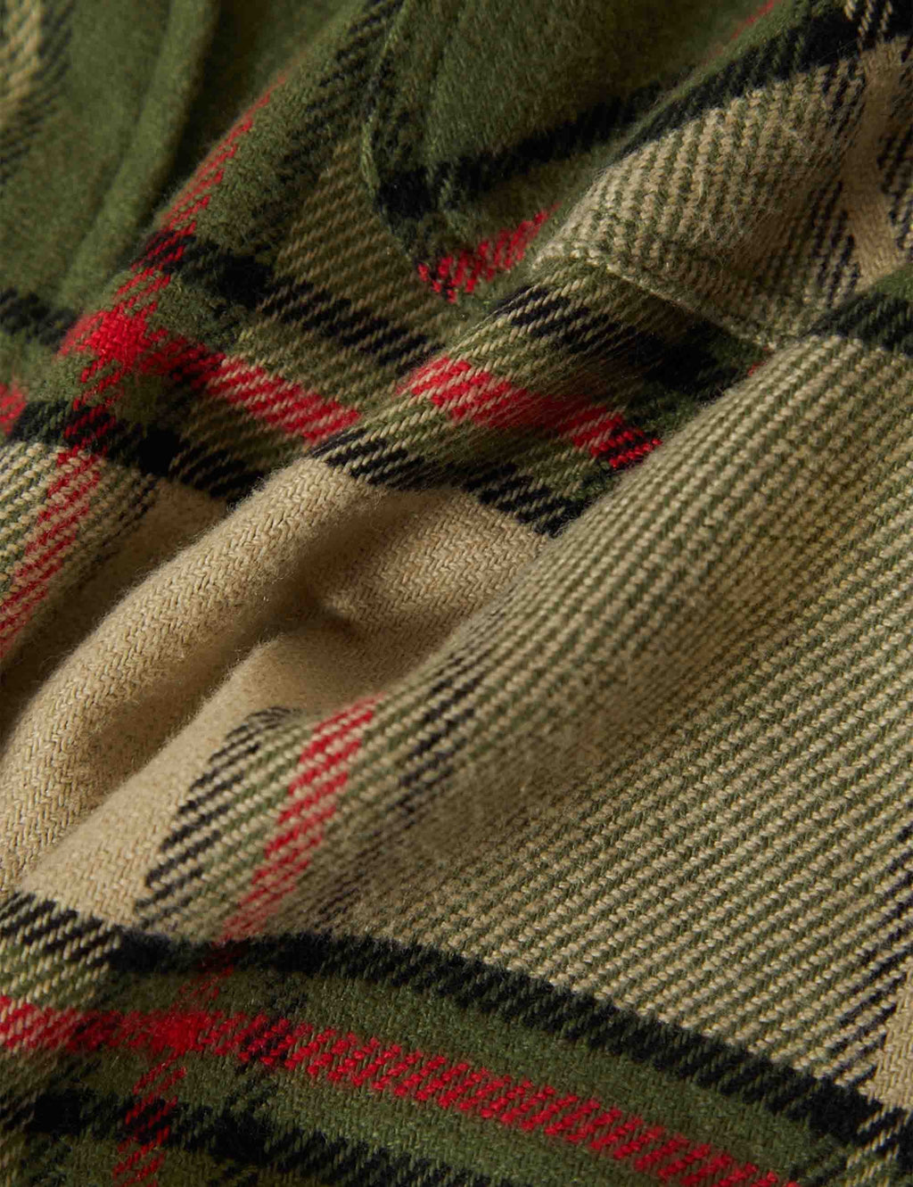 Plaid flannel fabric texture with green, red, and cream checks