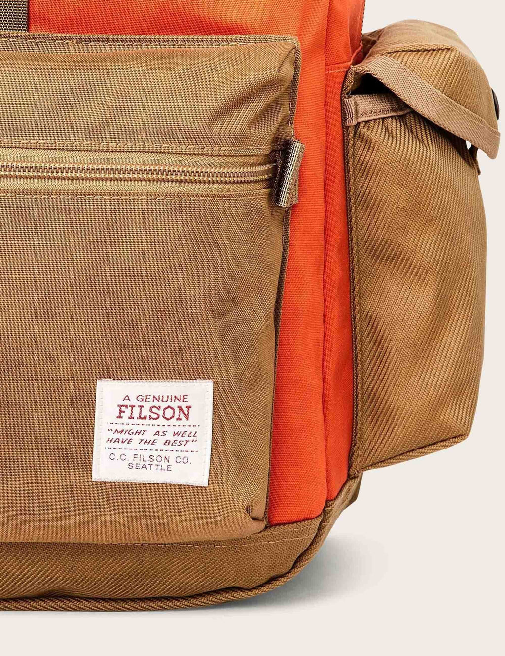 Tan and orange backpack side pocket with zipper and Filson logo patch